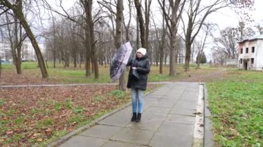 Yağmurlu havada parkta yürüyen bir kadın..