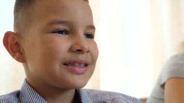 Çocuk masada otururken peynir yiyor..