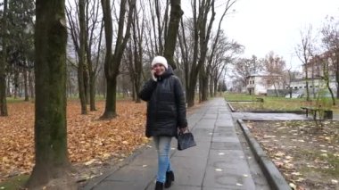 Yağmurlu havada parkta yürüyen bir kadın..
