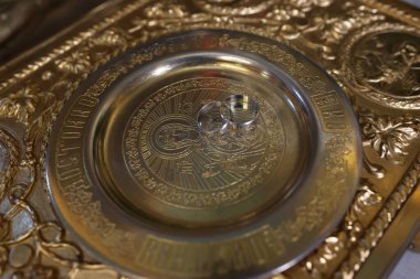 Kilisedeki bir tahtta altın tepside alyanslar. Kilise düğünü.