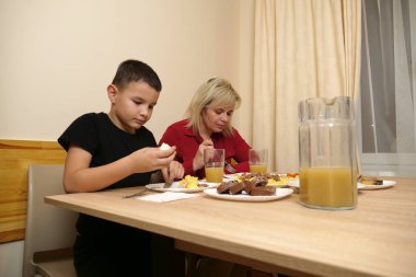 Festival masasında, anne ve oğluna yiyecek ve içecek ikram edilir..