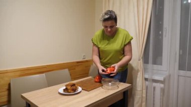 Bir kadın akşam yemeği için sebzeli tavuk hazırlıyor..