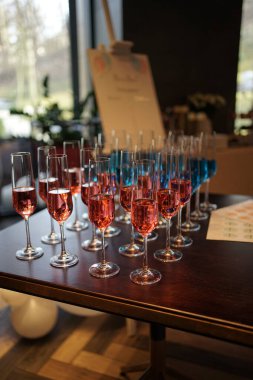 Şenlik masasında pembe ve mavi şarap kadehleri.