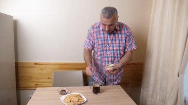 Adam mutfakta kahvaltı için kahve yapıyor.