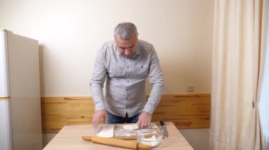 Bir adam mutfaktaki hamur işlerinden hamur işi yapar..