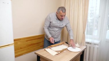 Bir adam mutfaktaki hamur işlerinden hamur işi yapar..