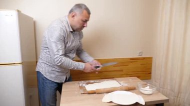 Bir adam mutfaktaki hamur işlerinden hamur işi yapar..