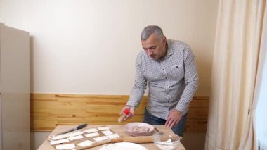 Bir adam mutfaktaki hamur işlerinden hamur işi yapar..