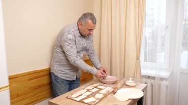 Bir adam mutfaktaki hamur işlerinden hamur işi yapar..