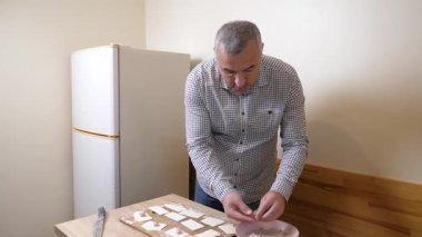 Bir adam mutfaktaki hamur işlerinden hamur işi yapar..