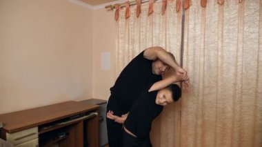 Bir adam ve oğlu evde spor yapıyor..