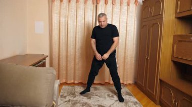 Bir adam evde spor yapıyor..