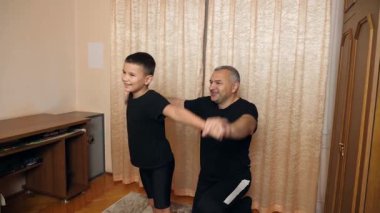 Bir adam ve oğlu evde spor yapıyor..