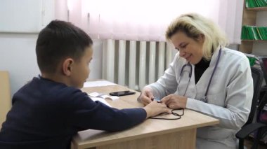 Doktor çocuğun oksijen doygunluğunu ölçer. Tıbbi muayene.