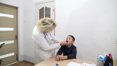 Doktor çocuğun boğazını muayene ediyor. Tıbbi muayene.