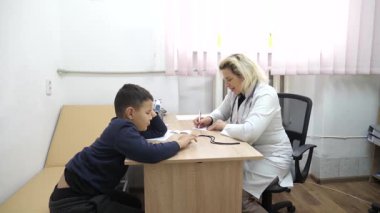 Doktor çocuğun durumunu tarif ediyor. Tıbbi muayene.