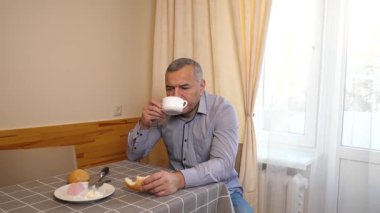 Adam kahvaltıdan sonra bulaşıkları yıkıyor..