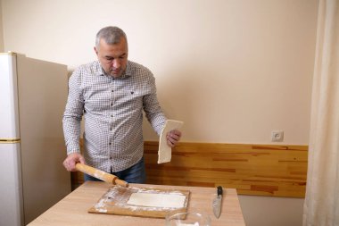 Bir adam mutfaktaki hamur işlerinden hamur işi yapar..