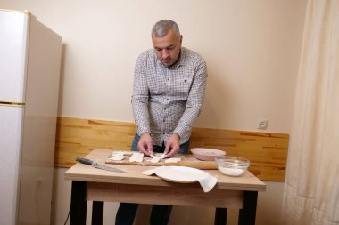 Bir adam mutfaktaki hamur işlerinden hamur işi yapar..