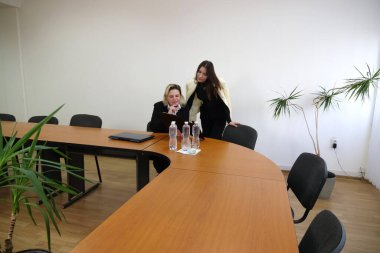 İki kadın iş konuşmak ve sözleşme imzalamak için bir ofiste buluşuyor..