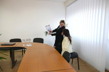 İki kadın iş konuşmak ve sözleşme imzalamak için bir ofiste buluşuyor..