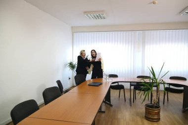 İki kadın iş konuşmak ve sözleşme imzalamak için bir ofiste buluşuyor..