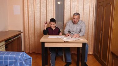 Baba oğluna ev ödevinde yardım ediyor. Ev eğitimi kavramı.