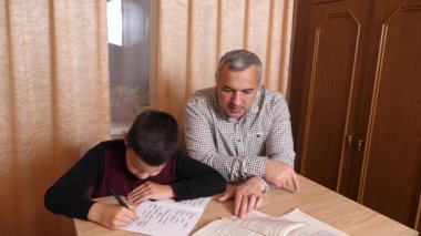 Baba oğluna ev ödevinde yardım ediyor. Ev eğitimi kavramı.