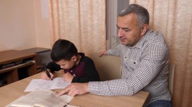 Baba oğluna ev ödevinde yardım ediyor. Ev eğitimi kavramı.