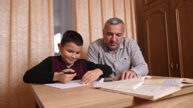 Baba oğluna ev ödevinde yardım ediyor. Ev eğitimi kavramı.