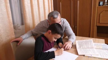 Baba oğluna ev ödevinde yardım ediyor. Ev eğitimi kavramı.