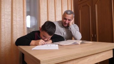 Baba oğluna ev ödevinde yardım ediyor. Ev eğitimi kavramı.