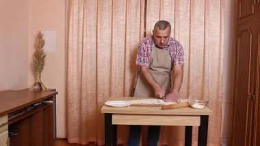 Bir adam hamurdan ve tatlı dolgudan turtalar hazırlar. Ev yapımı yemekler..