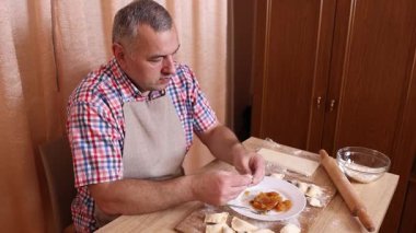 Bir adam hamurdan ve tatlı dolgudan turtalar hazırlar. Ev yapımı yemekler..