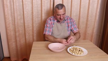 Fıstıkları elle soyan bir adam. Sağlıklı beslenme.