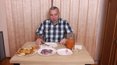 Adam masada otururken yemek ve içki yiyor. Ev yemekleri..