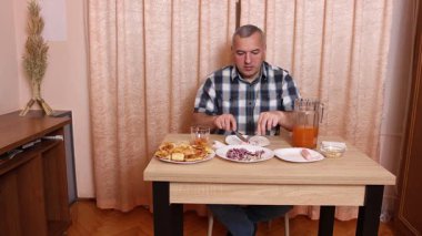 Adam masada otururken yemek ve içki yiyor. Ev yemekleri..