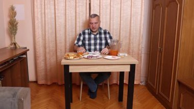 Adam masada otururken yemek ve içki yiyor. Ev yemekleri..