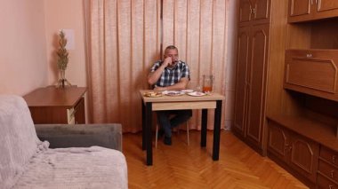 Adam masada otururken yemek ve içki yiyor. Ev yemekleri..