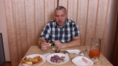 Adam masada otururken yemek ve içki yiyor. Ev yemekleri..