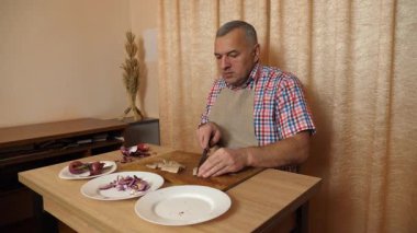 Bir adam soğanlı ringa balığı pişiriyor. Ev yemeği..