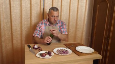 Bir adam soğanlı ringa balığı pişiriyor. Ev yemeği..