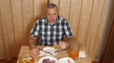 Adam masada otururken yemek ve içki yiyor. Ev yemekleri..