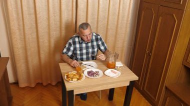 Adam masada otururken yemek ve içki yiyor. Ev yemekleri..