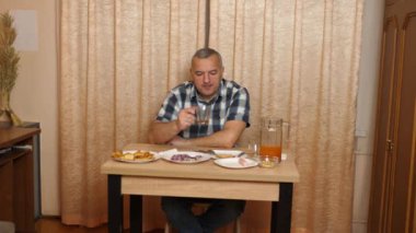 Adam masada otururken yemek ve içki yiyor. Ev yemekleri..