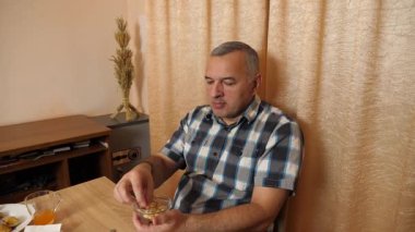 Adam masada otururken yemek ve içki yiyor. Ev yemekleri..