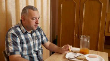 Adam masada otururken yemek ve içki yiyor. Ev yemekleri..