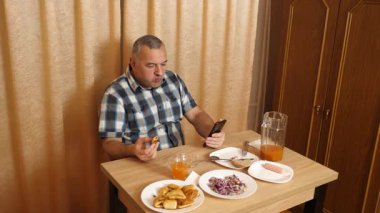 Adam masada otururken yemek ve içki yiyor. Ev yemekleri..