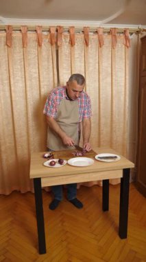 Bir adam soğanlı ringa balığı pişiriyor. Ev yemeği..