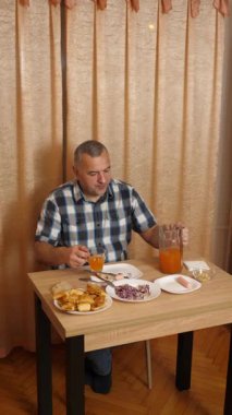 Adam masada otururken yemek ve içki yiyor. Ev yemekleri..